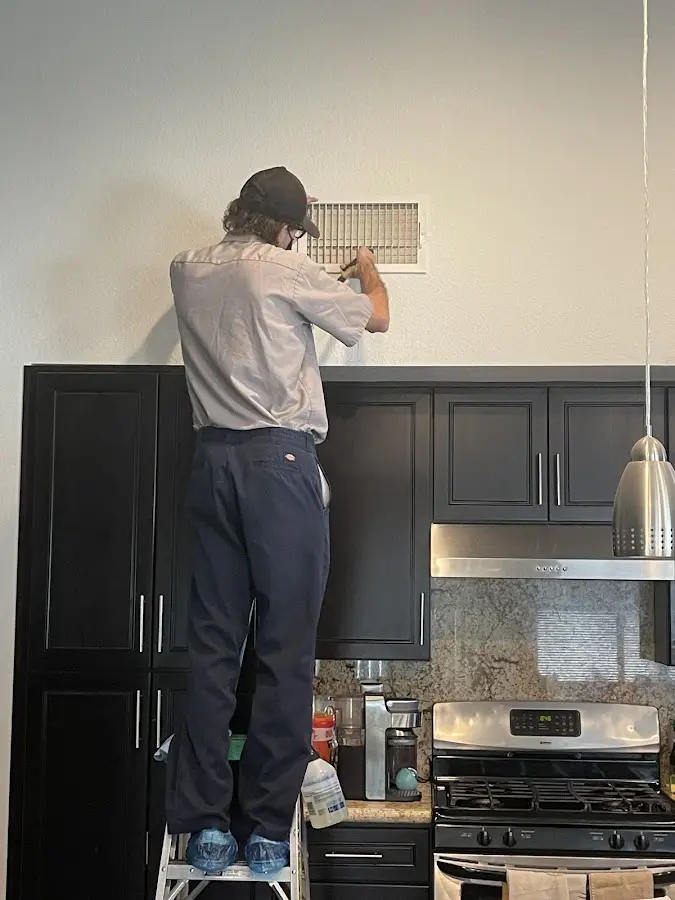 Technician inspecting an air vent during HVAC service in Gaffney